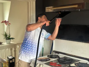Sygora cleaner cleaning the underside of a range hood.
