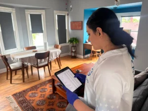 Sygora cleaner reviewing a digital cleaning checklist on a tablet.