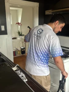 Sygora cleaner working at a kitchen stove.