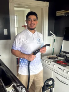 Sygora cleaner holding a steam cleaner in a kitchen.