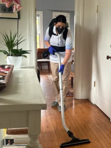 Sygora cleaner vacuuming a hardwood hallway floor.