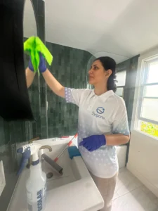 Sygora cleaner wiping a round bathroom mirror.